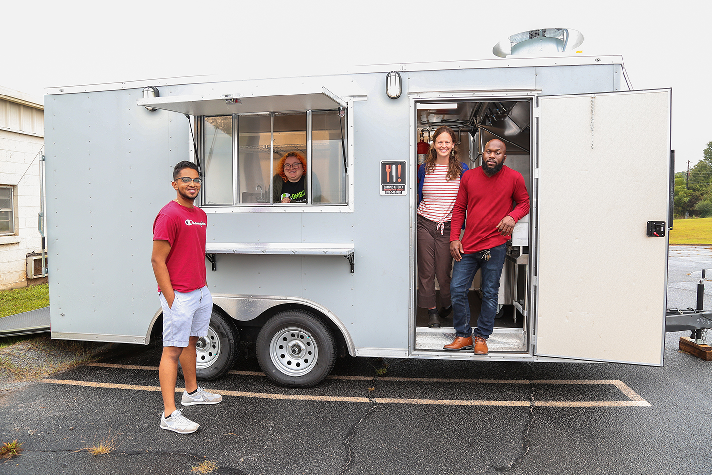 Members of Campus Kitchen pose with their food trailer