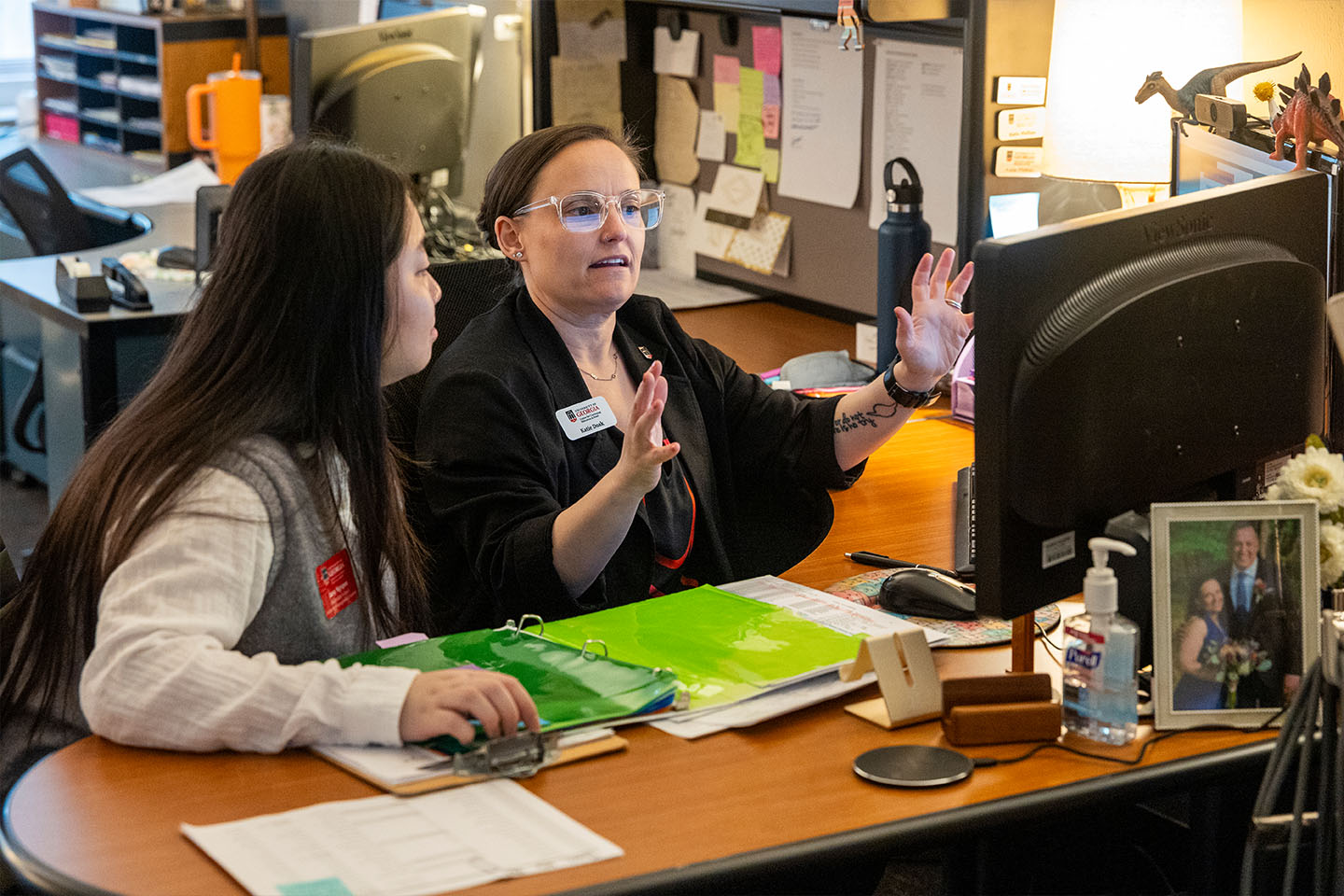a student and mentor collaborate in an office near a computer
