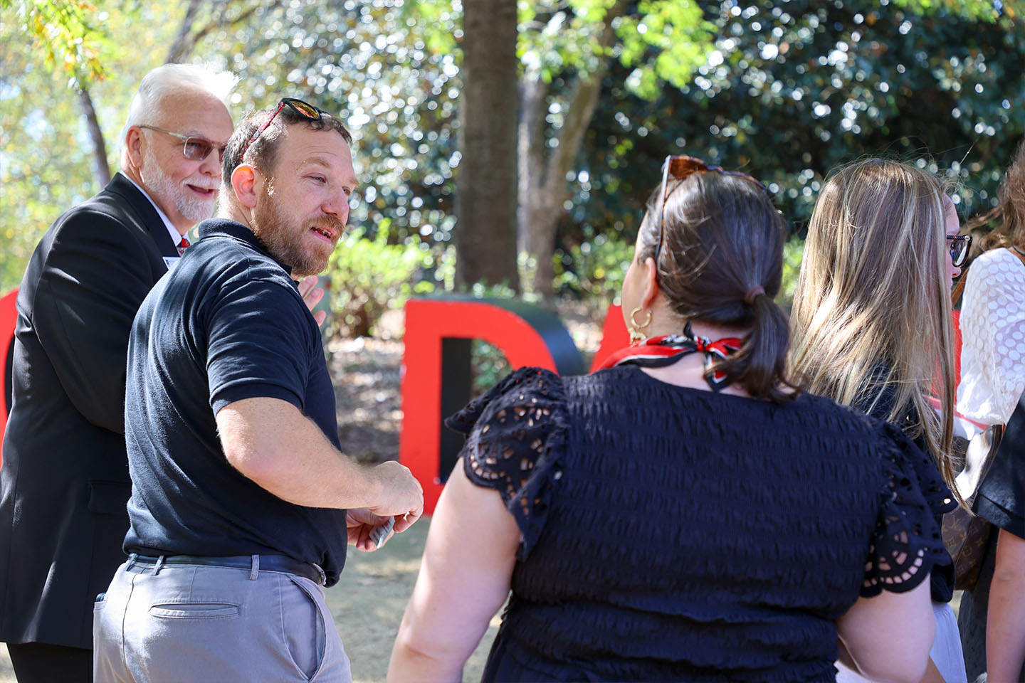 Josh Podvin talks with colleagues at an outdoor event