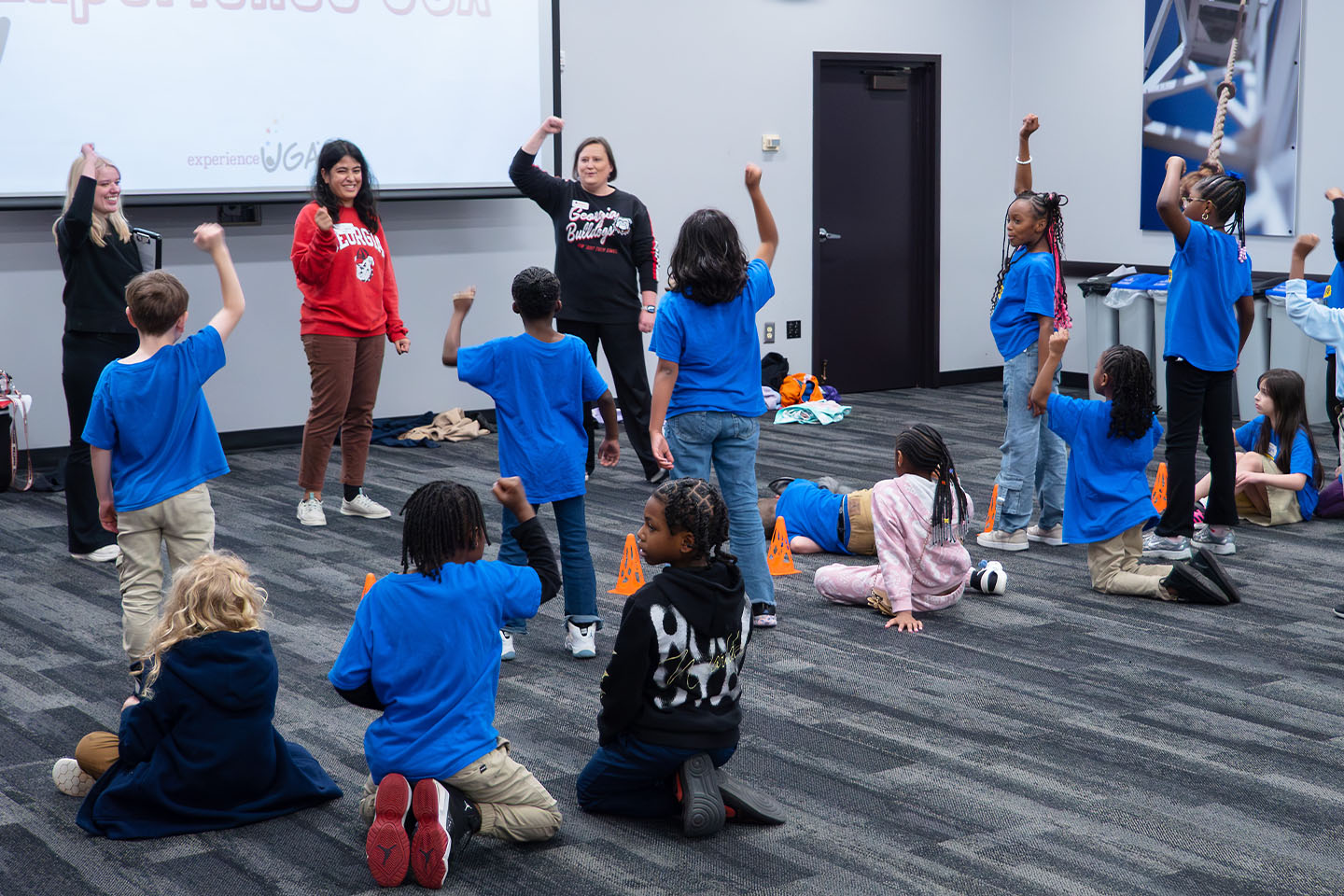 students standing and raising their hands as part of an activity