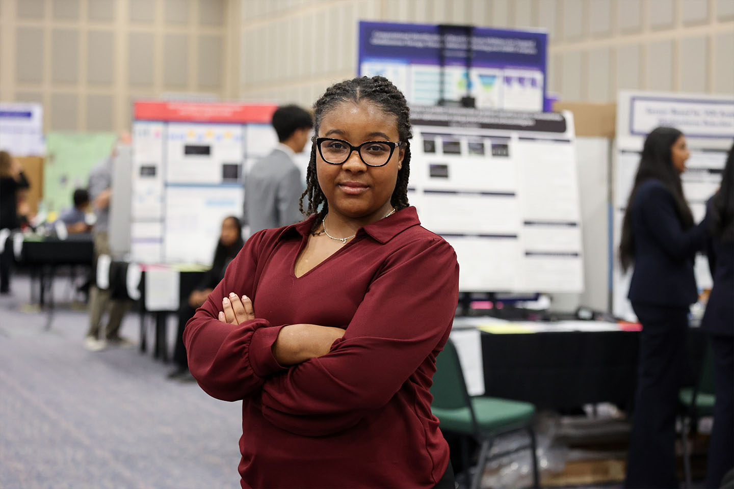 Dalila Harris stands in front of rows of Georgia Science and Engineering Fair projects.