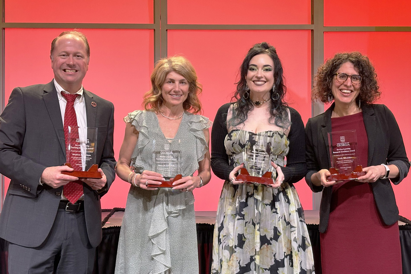 the four award winners standing with their trophies