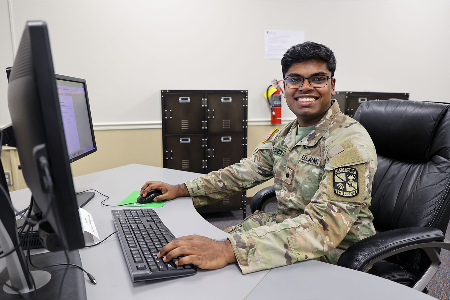 student in military uniform working at a computer