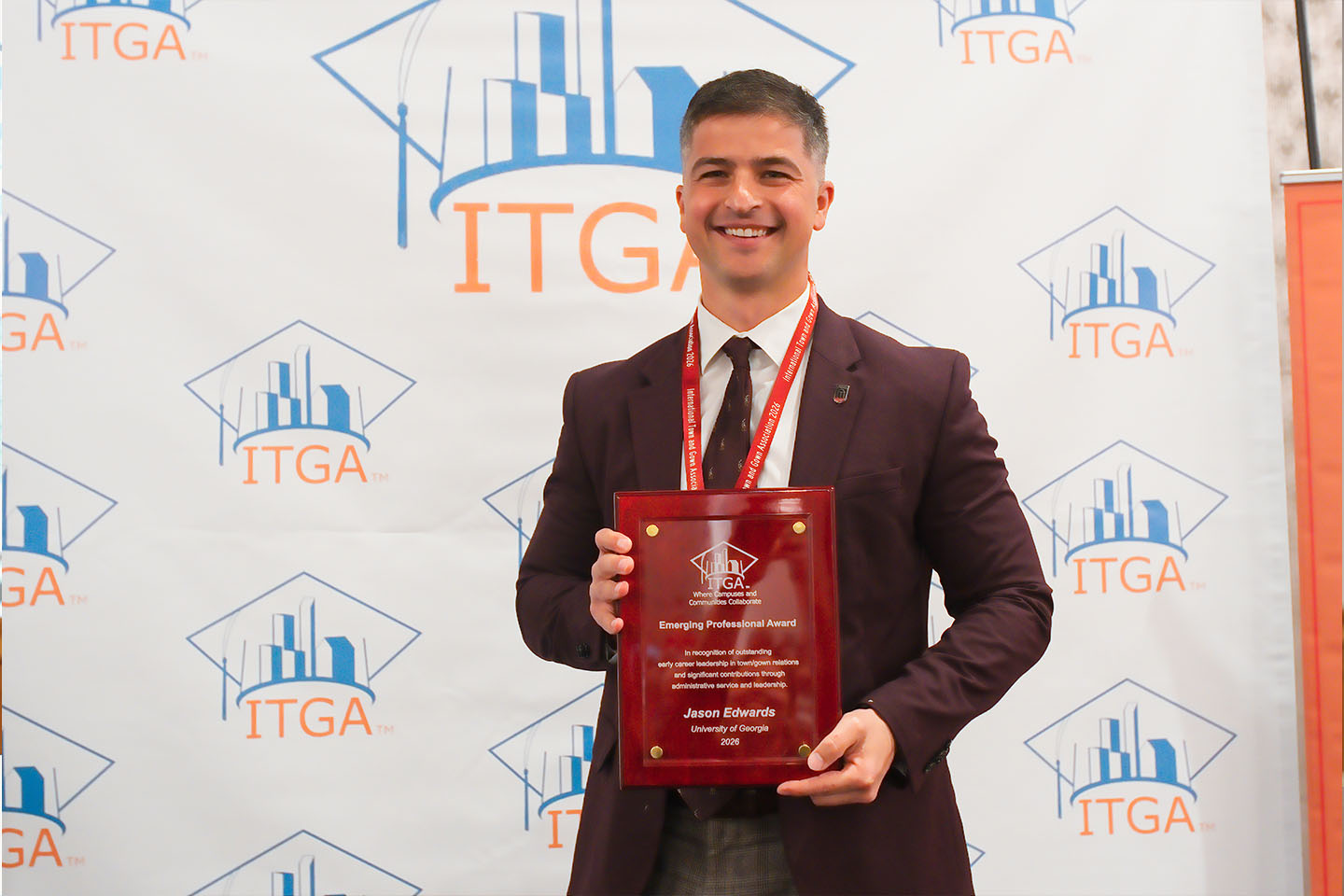 jason edwards in front of an ITGA backdrop holding award