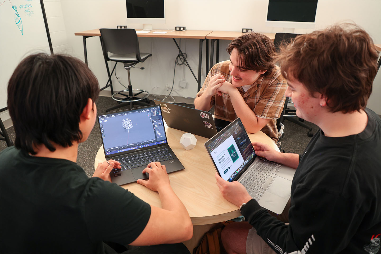 students collaborate on a laptop