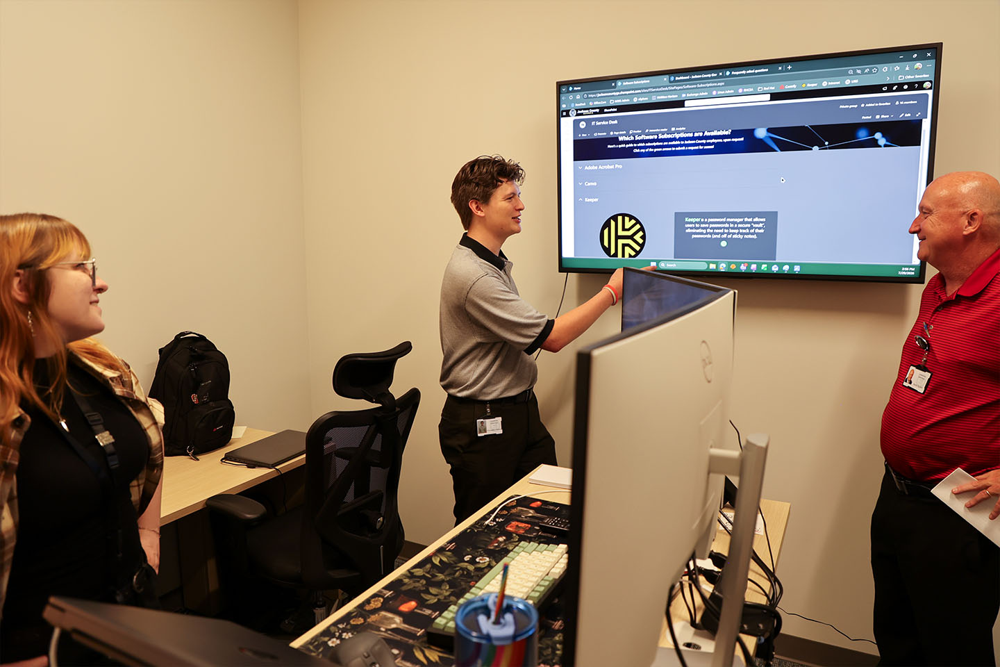 Christopher points to data on a screen in front of Barry and Anna Leigh.