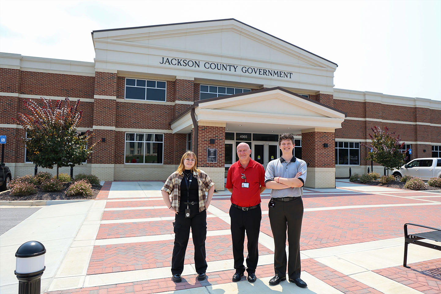 Christopher, Varry and Anna Leigh stand in front of the Jackson County Government Building.